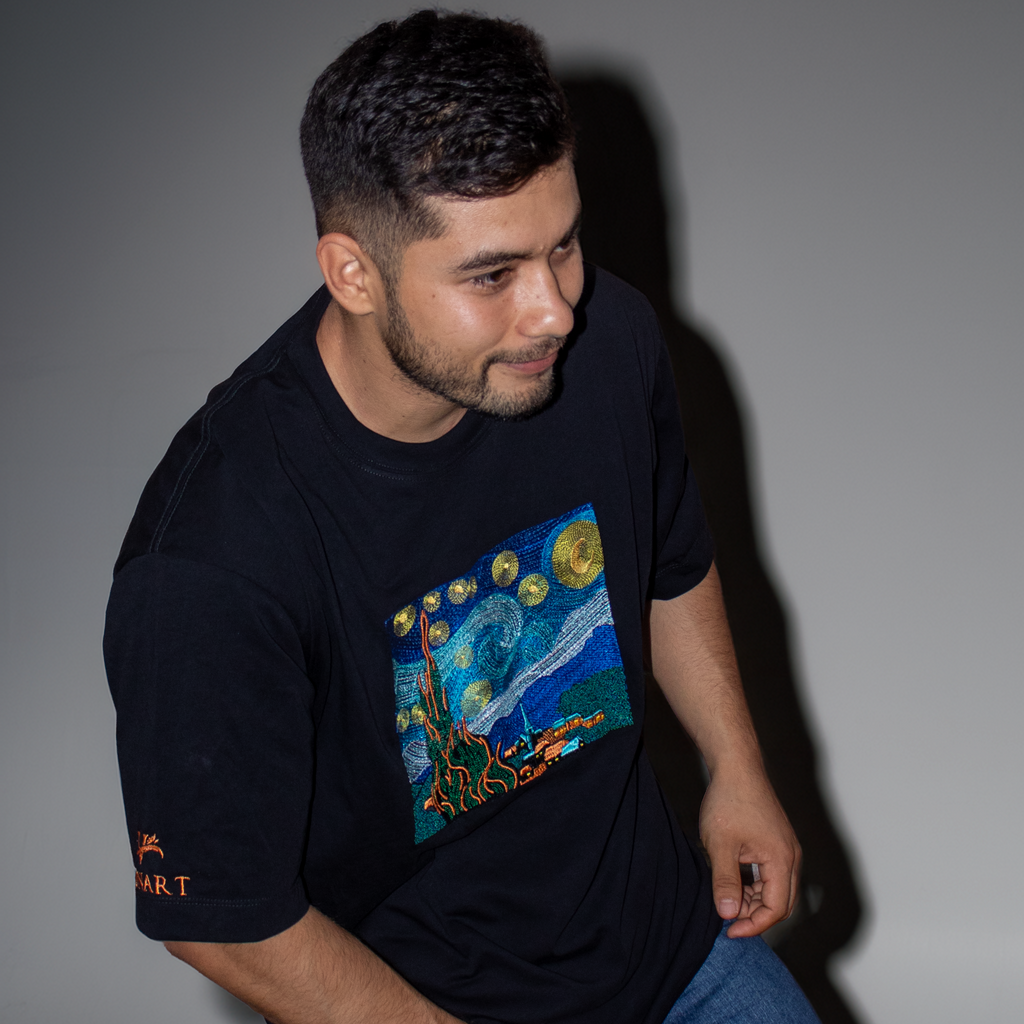 Man wearing a black t-shirt with a colorful graphic design on a plain background